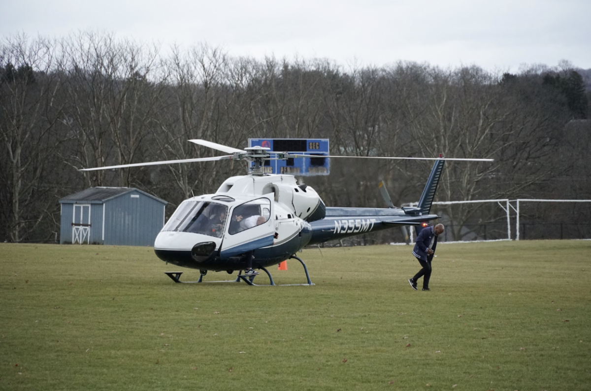 Coach Franklin lands his helicopter in the soccer field to meet with Andrew Olesh. 